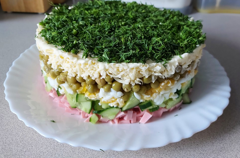 Слоёный салат с колбасой, сыром и зелёным горошком