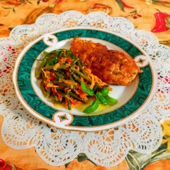 Шницель куриный и жареные чесночные стрелки с овощами