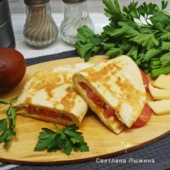 Тортилья с яйцом, сыром и помидорами на сковороде