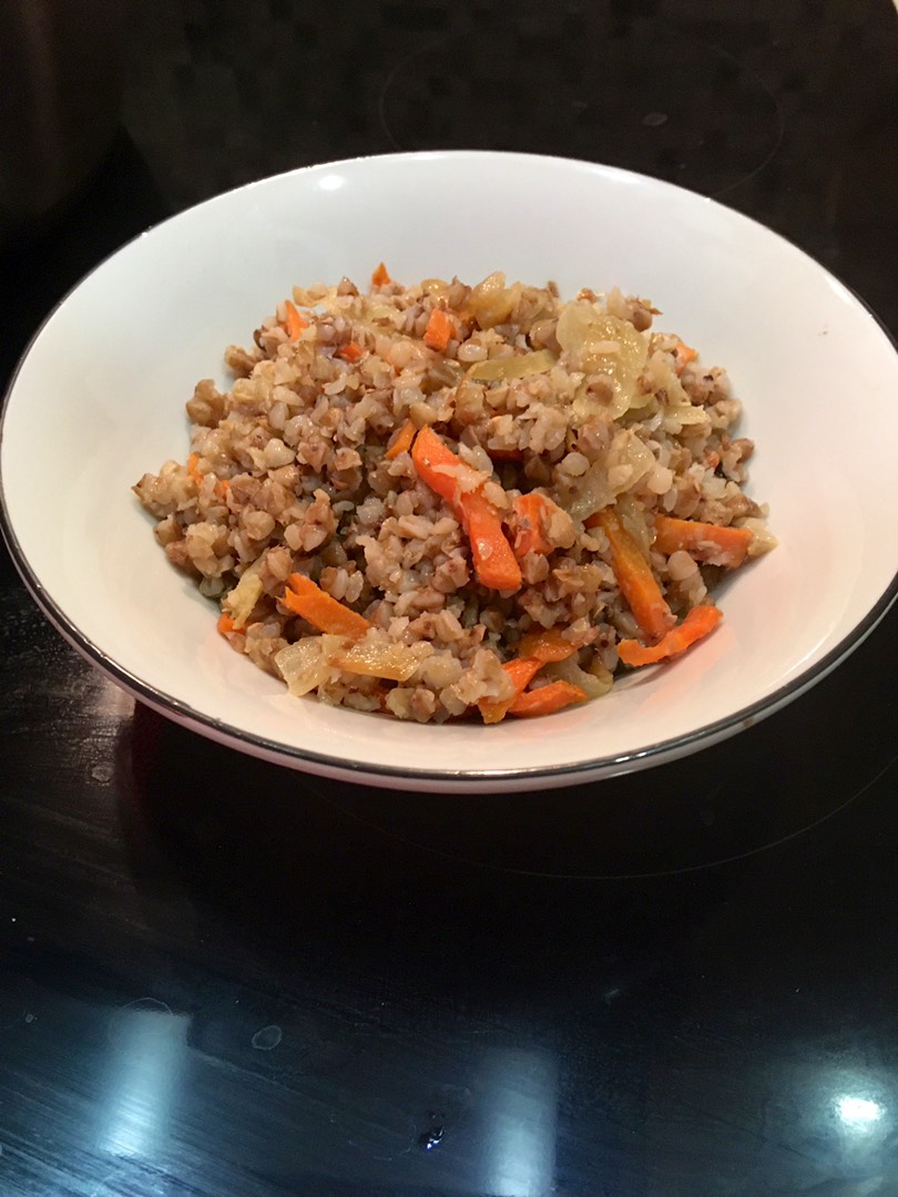 Жареный рис с луком и морковью на сковороде