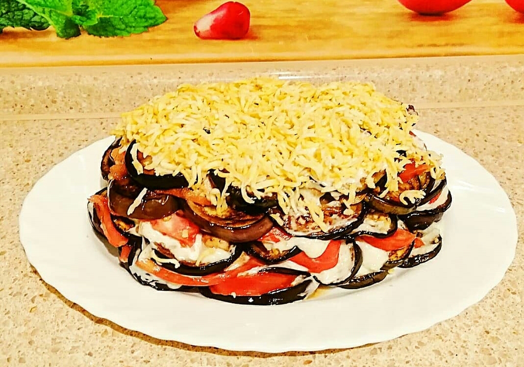 Обжаренные баклажаны с томатом, курицей и чесночным соусом