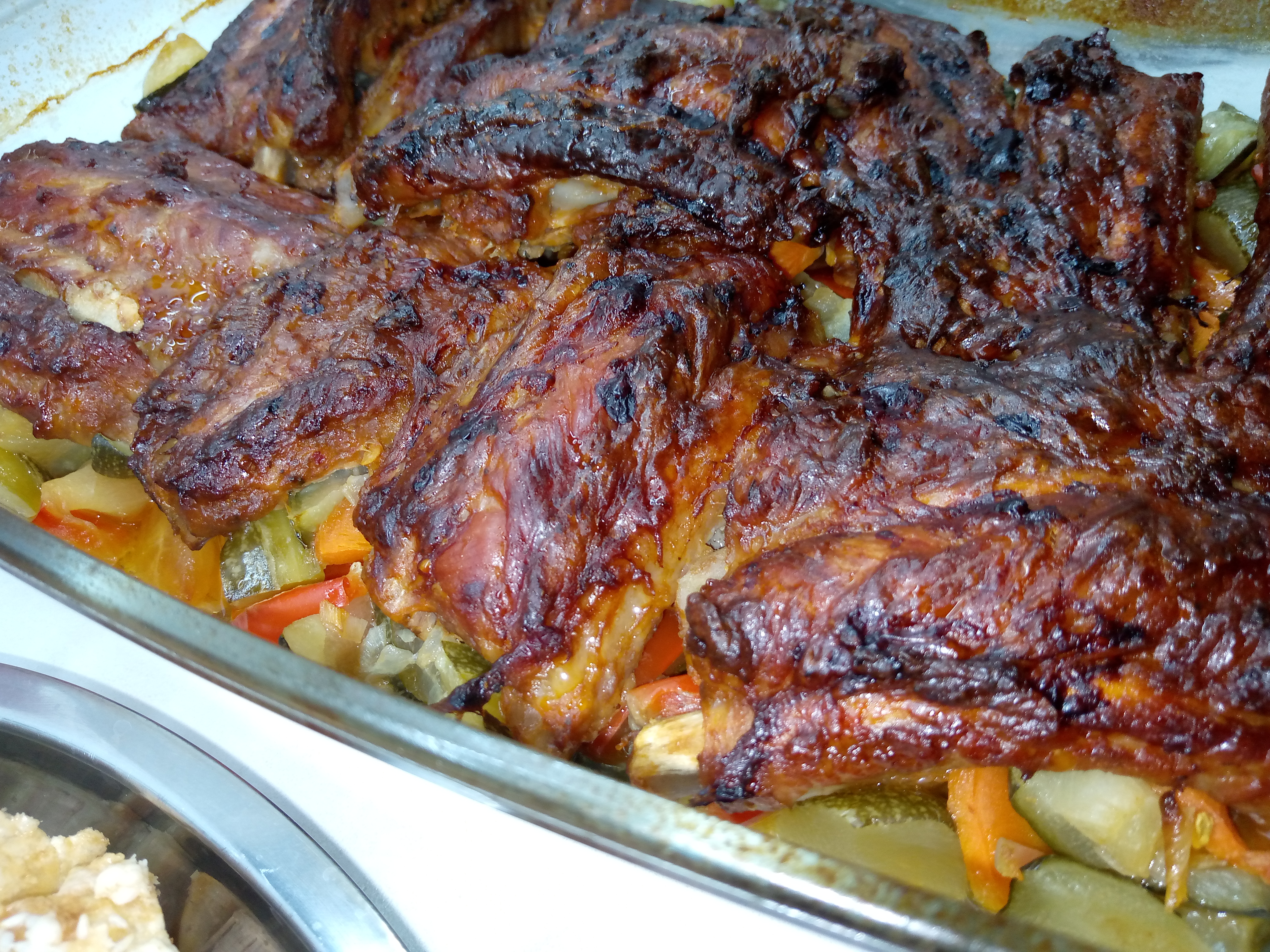 Маринованные свиные ребра с овощами в духовке