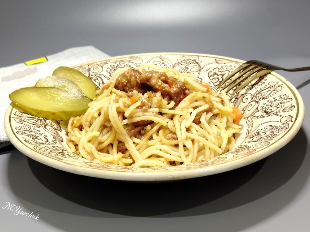 Спагетти с тушенкой и луком на сковороде