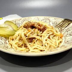 Спагетти с тушенкой и луком на сковороде