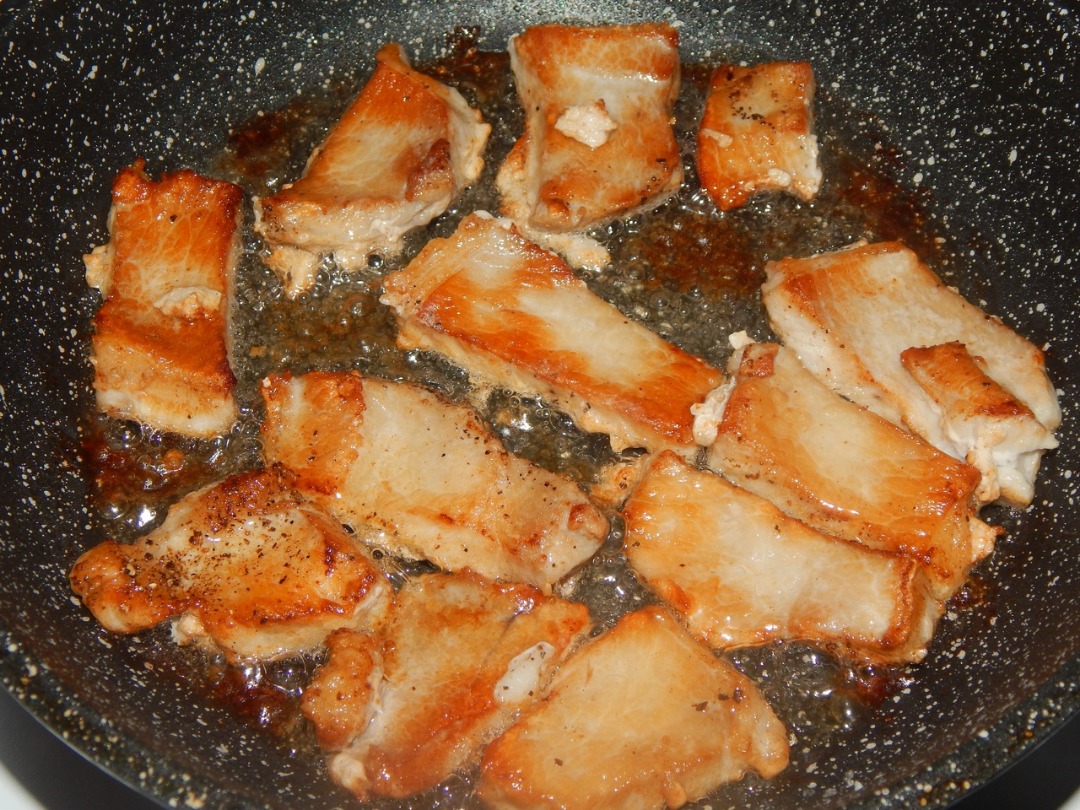 Мясо свинины, тушеное кусочками на сковороде